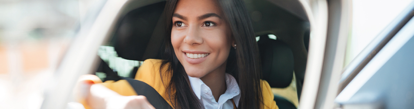 a woman sitting inside her new automobile