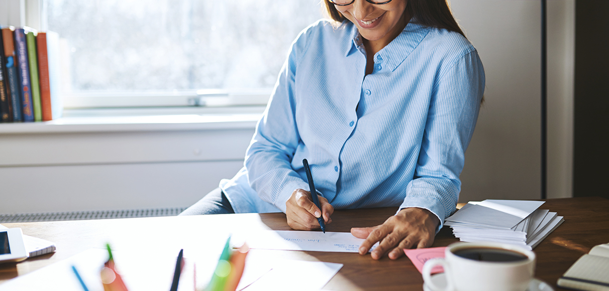 a woman writing on a piece of paper