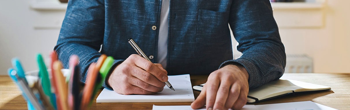 a person writing in a ledger